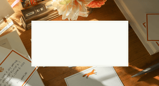 Stationery items including cards and envelopes on a wooden surface.